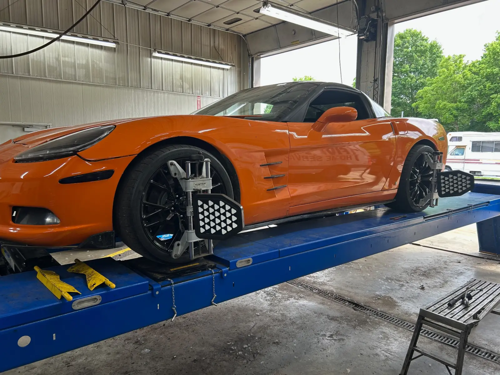 Orange Chevrolet Corvette on the alignment rack at Pitt Stop Tire & Auto in Xenia, OH