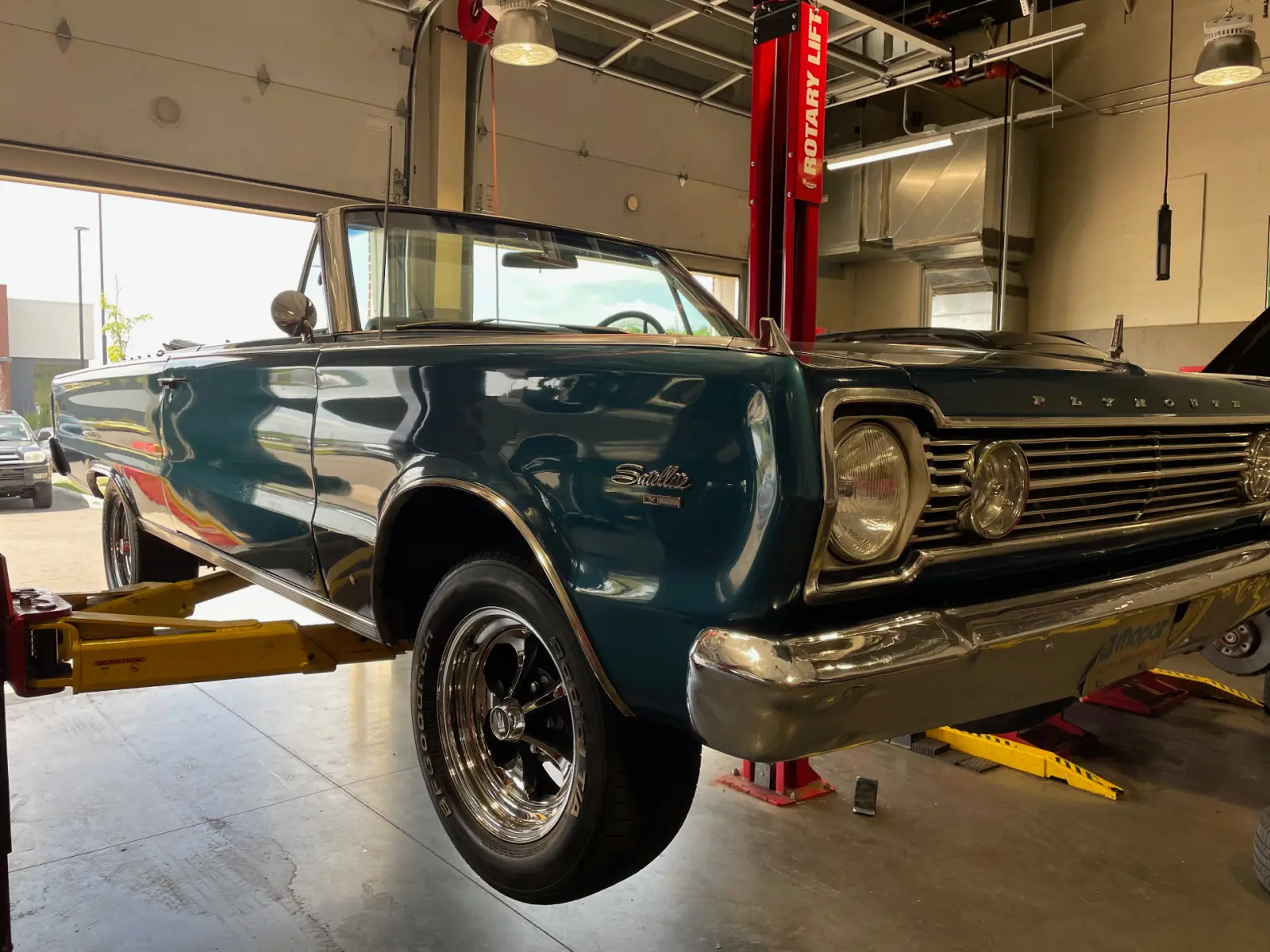 Teal Plymouth Satellite convertible on the lift at Pitt Stop Tire & Auto in Xenia, OH